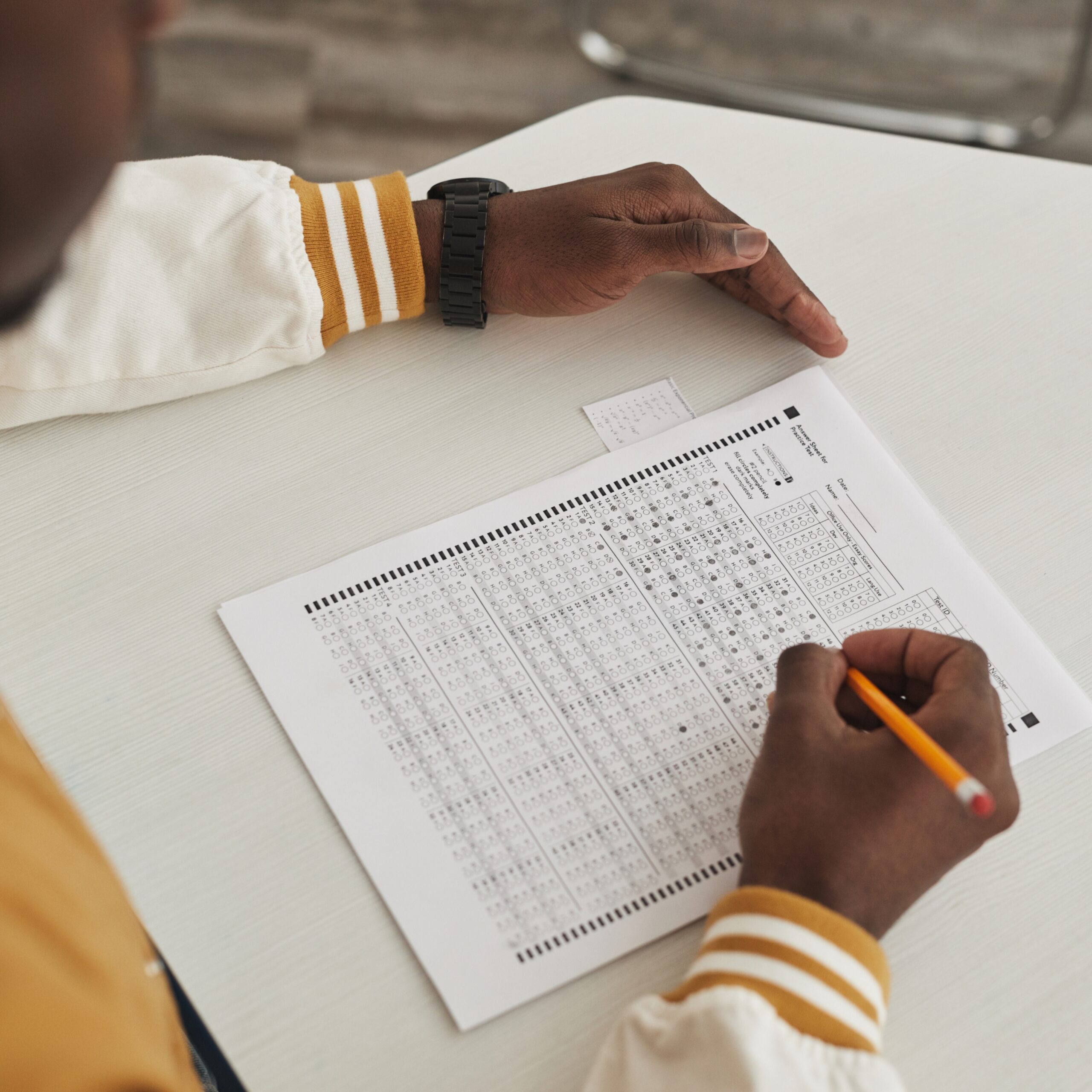 Person filling in a printed questionnaire with a pencil