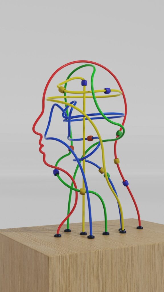 Sculpture of a human head in profile made of coloured wires on a wooden block