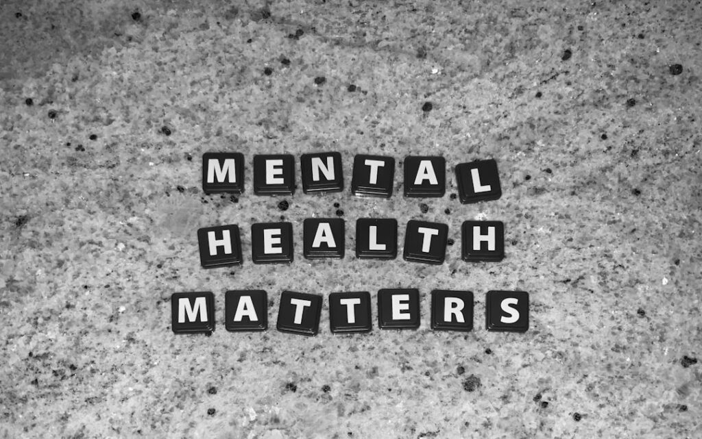 Letter tiles spelling Mental Health Matters on a grey stone surface