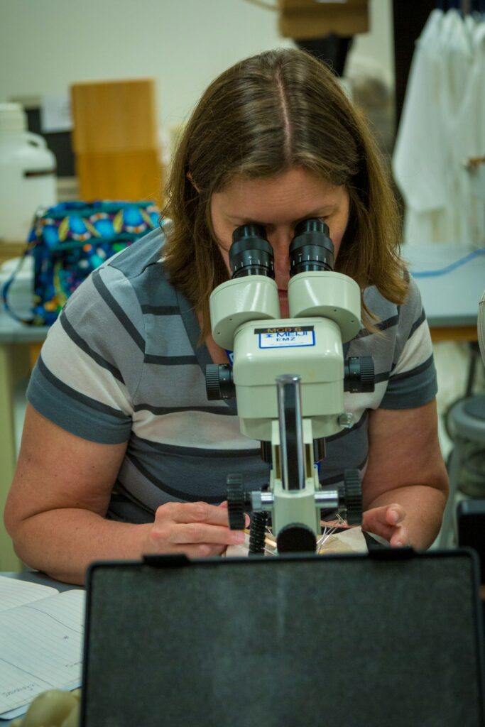 Woman looking through a laboratory microscope